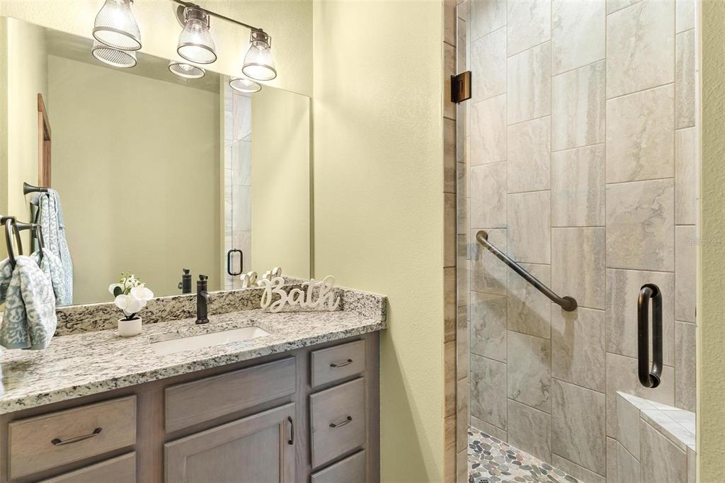 37590 Rolling Acres Road Lady Lake, FL 32159 - Photo 17 of 30 a bathroom with a granite countertop sink a mirror and shower