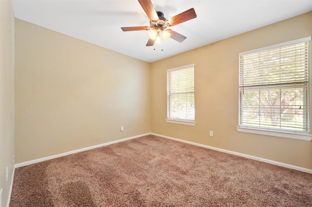 7517 Point Reyes Drive Fort Worth, TX 76137 - Photo 17 of 30 Neutral-toned interior room featuring two windows with blinds, brown carpeting, and a ceiling fan with light fixture
