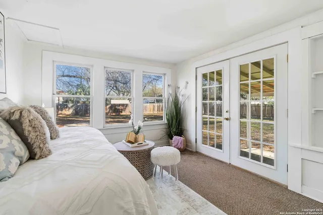 a spacious bedroom with a bed and glass window