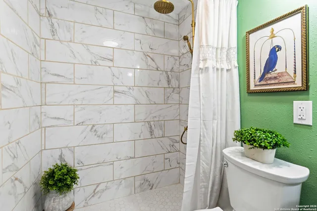 a bathroom with a toilet and a shower curtain