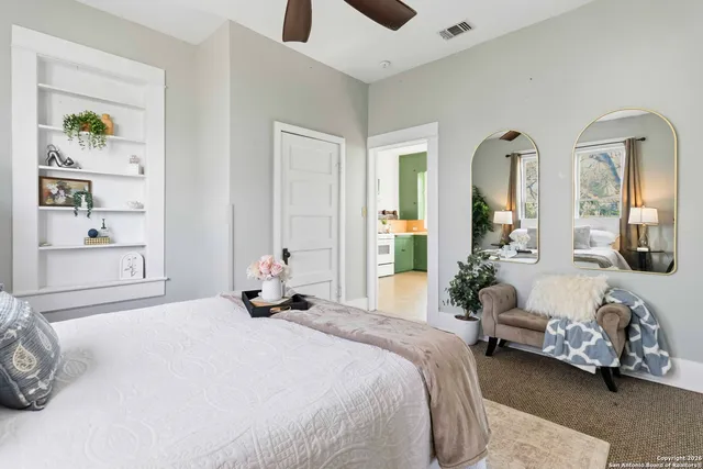 a bedroom with a bed and a large mirror