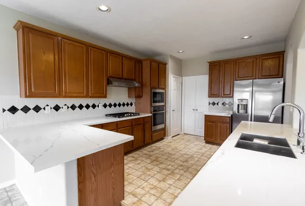 a kitchen with stainless steel appliances granite countertop a sink stove and refrigerator