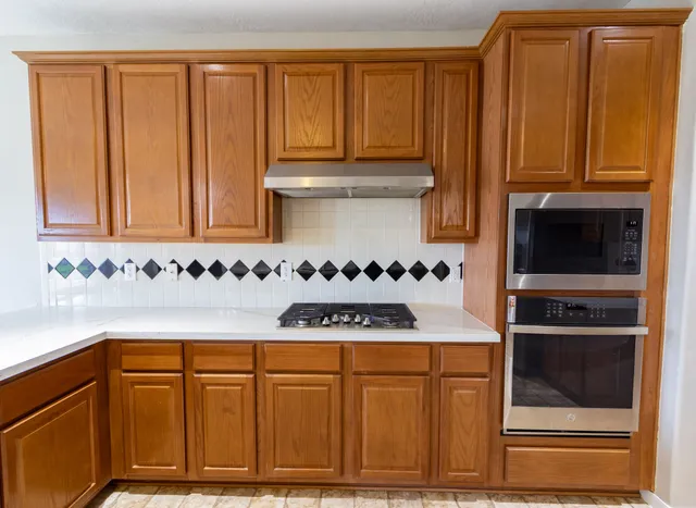 a kitchen with granite countertop cabinets and black appliances