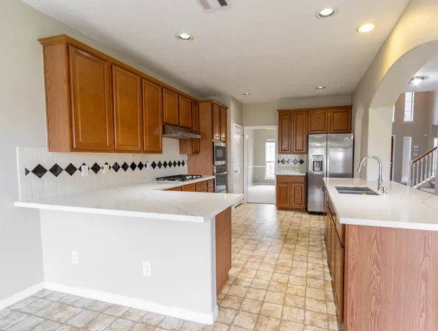 a kitchen with stainless steel appliances granite countertop a sink and a stove