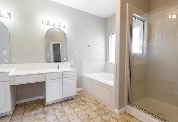 a spacious bathroom with a double vanity sink a mirror and a bathtub
