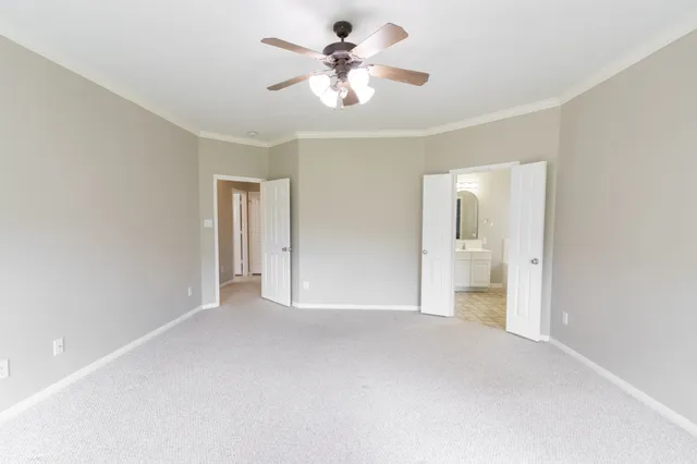 a view of a room with a ceiling fan and a bathroom
