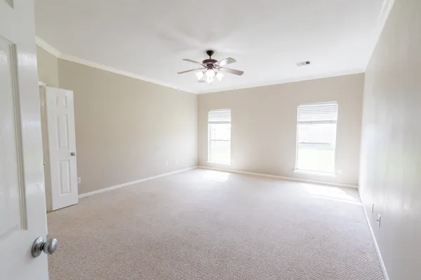 a view of empty room with window and ceiling fan