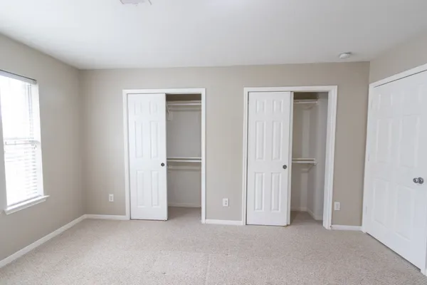 an empty room with windows and closet