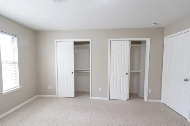 an empty room with windows and closet