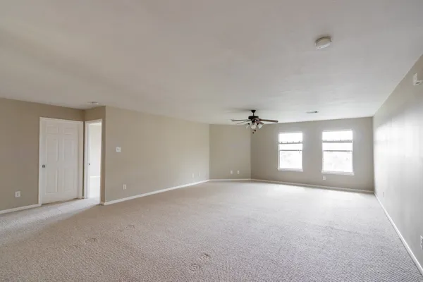 a view of a big room with windows and chandelier fan in a room