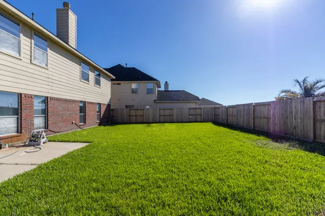 a view of a house with backyard and sitting area