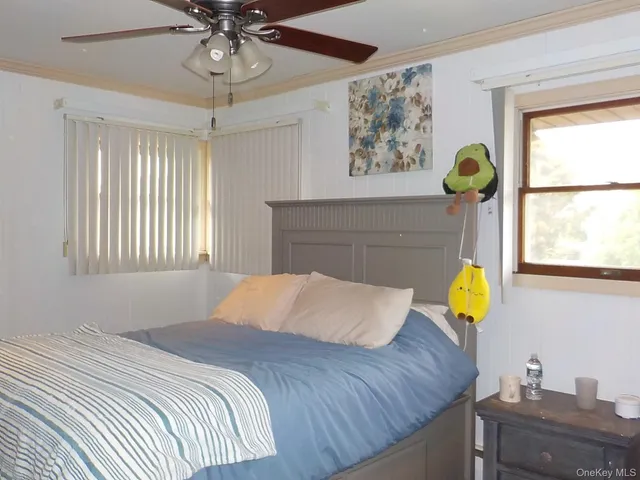 a bedroom with a bed mirror and a window
