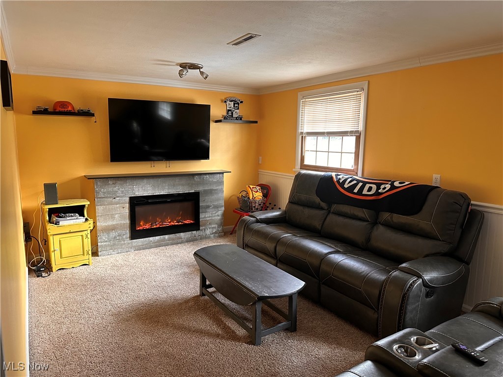 4034 Meister Road Lorain, OH 44053 - Photo 8 of 15 Living area featuring carpet, crown molding, and a glass covered fireplace