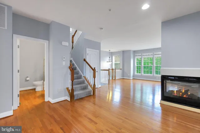 a view of a livingroom with wooden floor and a fireplace