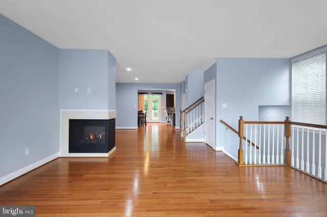a view of empty room with wooden floor and fireplace