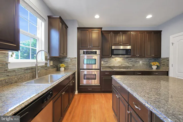 a kitchen with kitchen island granite countertop a stove sink and cabinets
