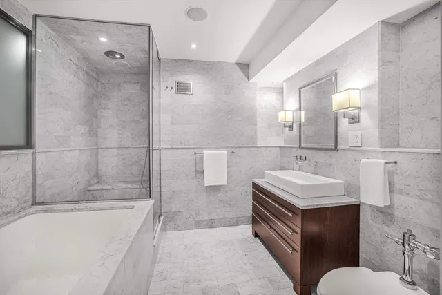 a bathroom with a sink toilet a mirror and shower