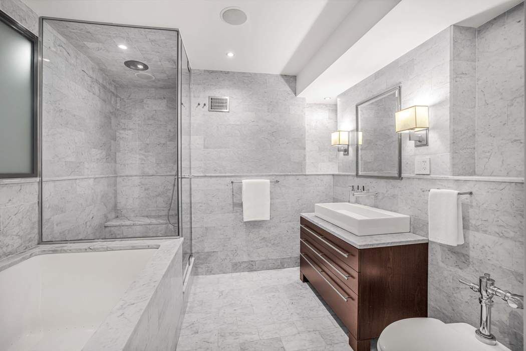 470 West 24th Street, Unit 7GJ Manhattan, NY 10011 - Photo 7 of 11 a bathroom with a sink and mirror with bathtub