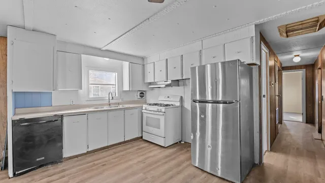 a kitchen with stainless steel appliances a refrigerator sink and cabinets