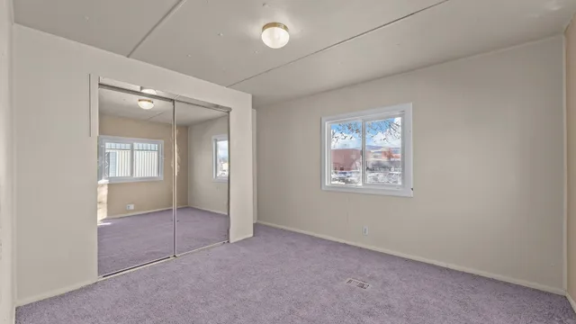 an empty room with windows and closet