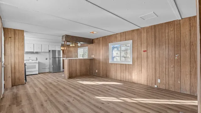 a view of a kitchen with wooden floor and a refrigerator