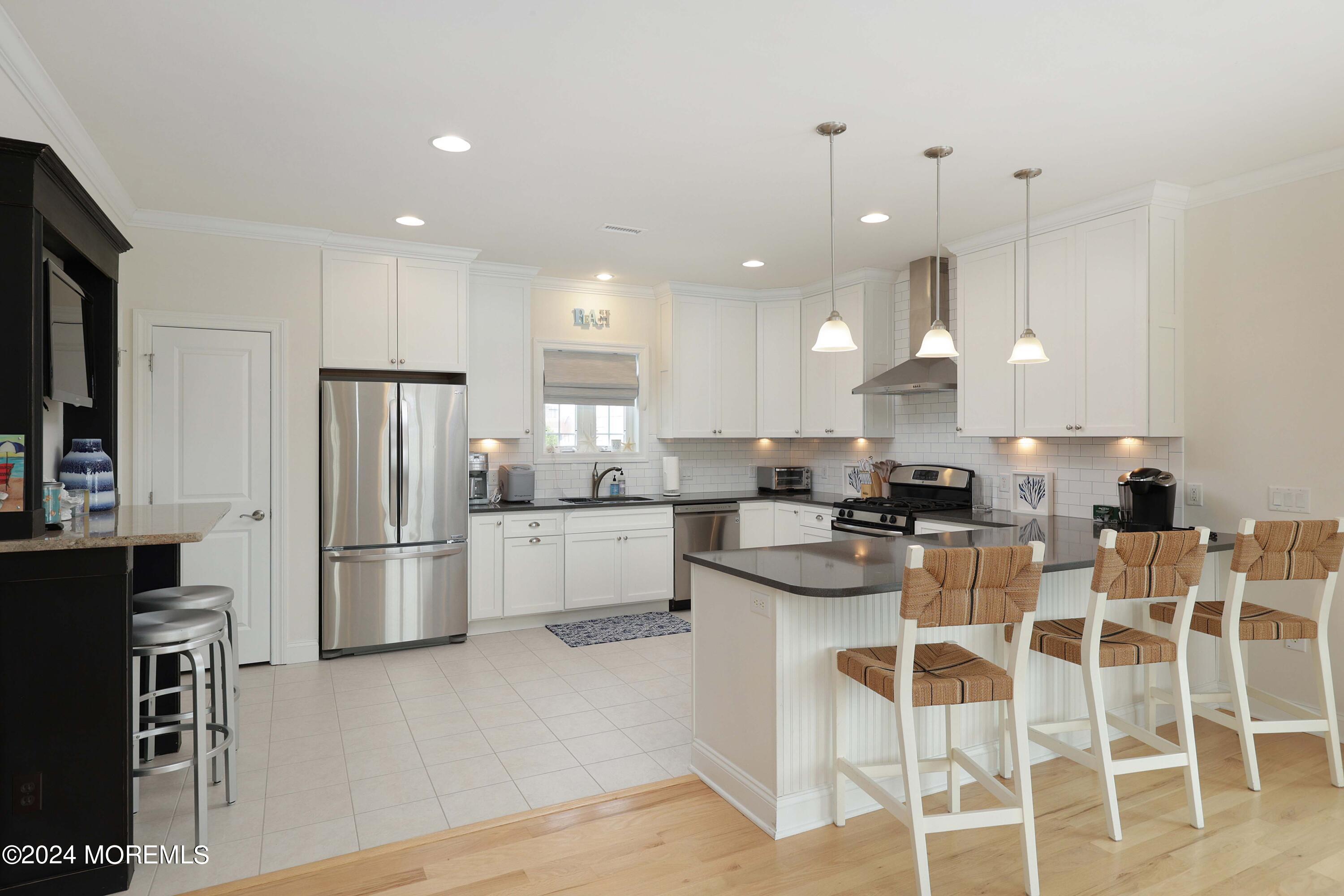 1607 Baltimore Avenue Lavallette, NJ 08735 - Photo 9 of 28 a kitchen with white cabinets and stainless steel appliances