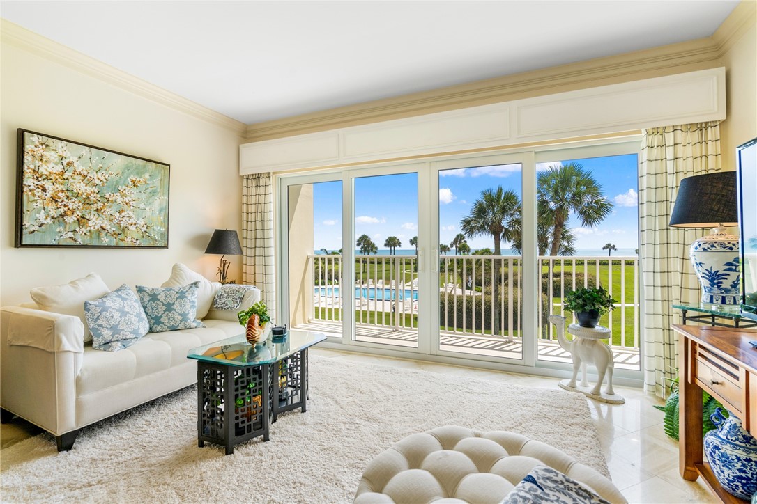 a living room with furniture a floor to ceiling window and a flat screen tv