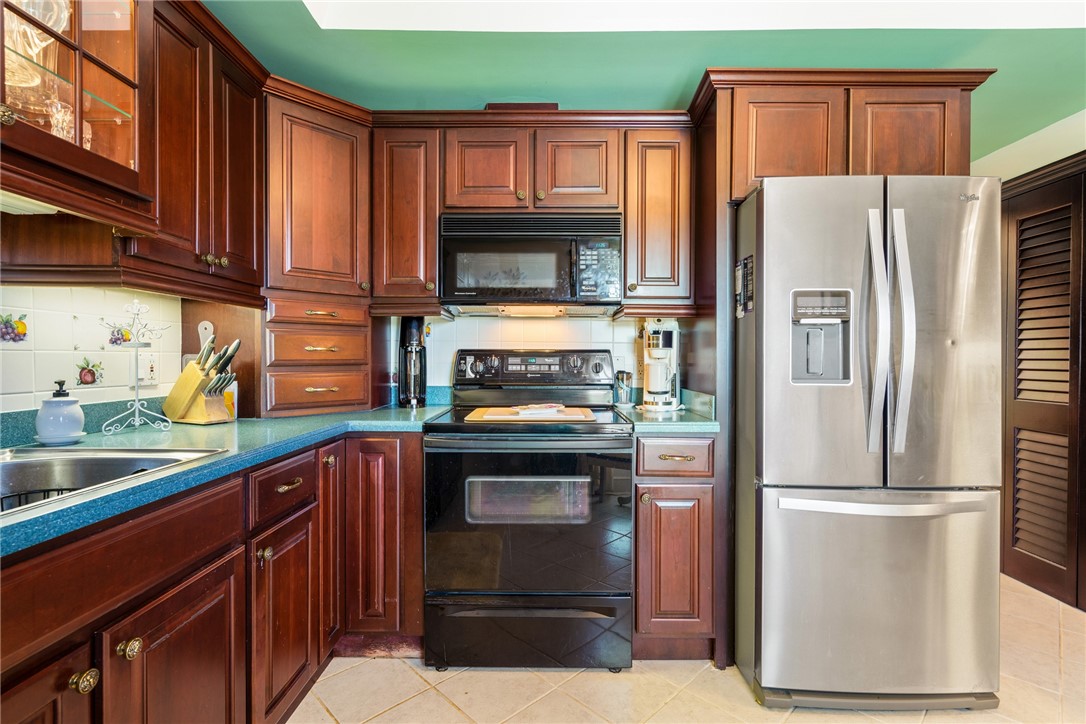 650 Beach Road, Unit 245 Vero Beach, FL 32963 - Photo 25 of 32 a kitchen with granite countertop a refrigerator stove and washer