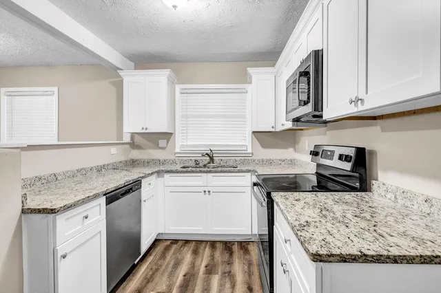 a kitchen with stainless steel appliances granite countertop a sink stove and cabinets