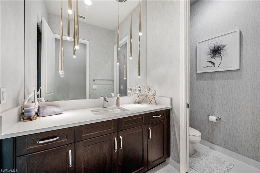 4462 Caldera Circle Naples, FL 34119 - Photo 16 of 33 a bathroom with a granite countertop sink a toilet and a mirror