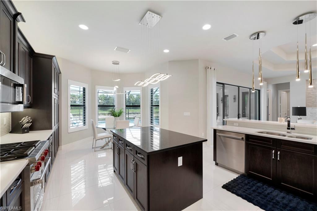 4462 Caldera Circle Naples, FL 34119 - Photo 9 of 33 a kitchen with granite countertop a sink stove and cabinets