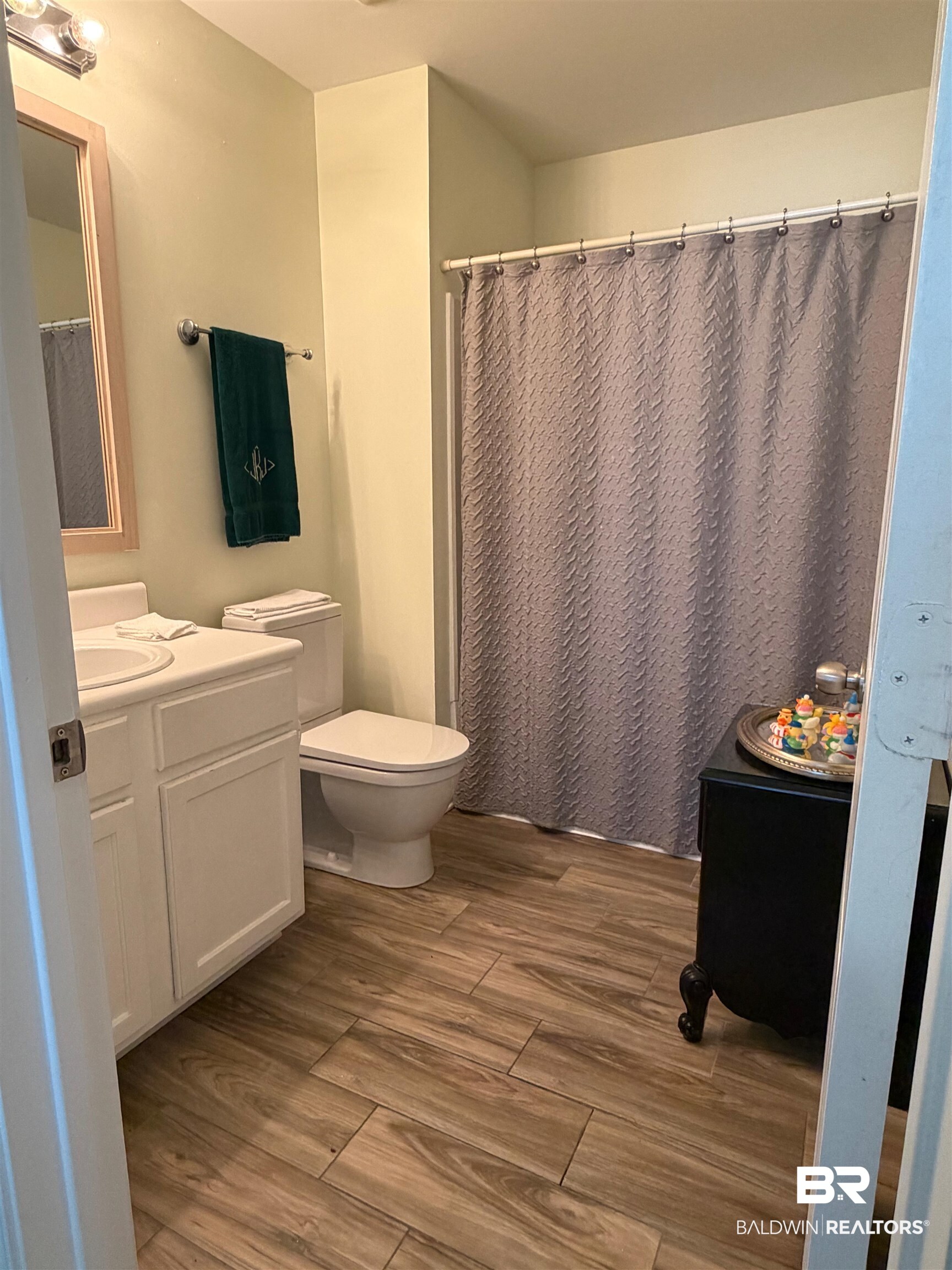 1517 Regency Road, Unit 71 Gulf Shores, AL 36542 - Photo 19 of 26 Bathroom featuring vanity, curtained shower, and dark wood-style floors