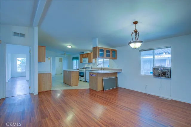 a kitchen with kitchen island stainless steel appliances sink and wooden floor