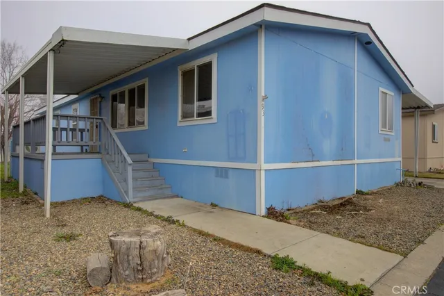 a yellow house with a yard and a large tree