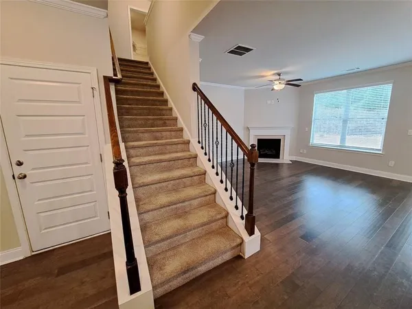 a view of a hallway with wooden floor and staircase