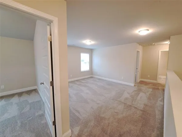 an empty room with windows and entrance to other room