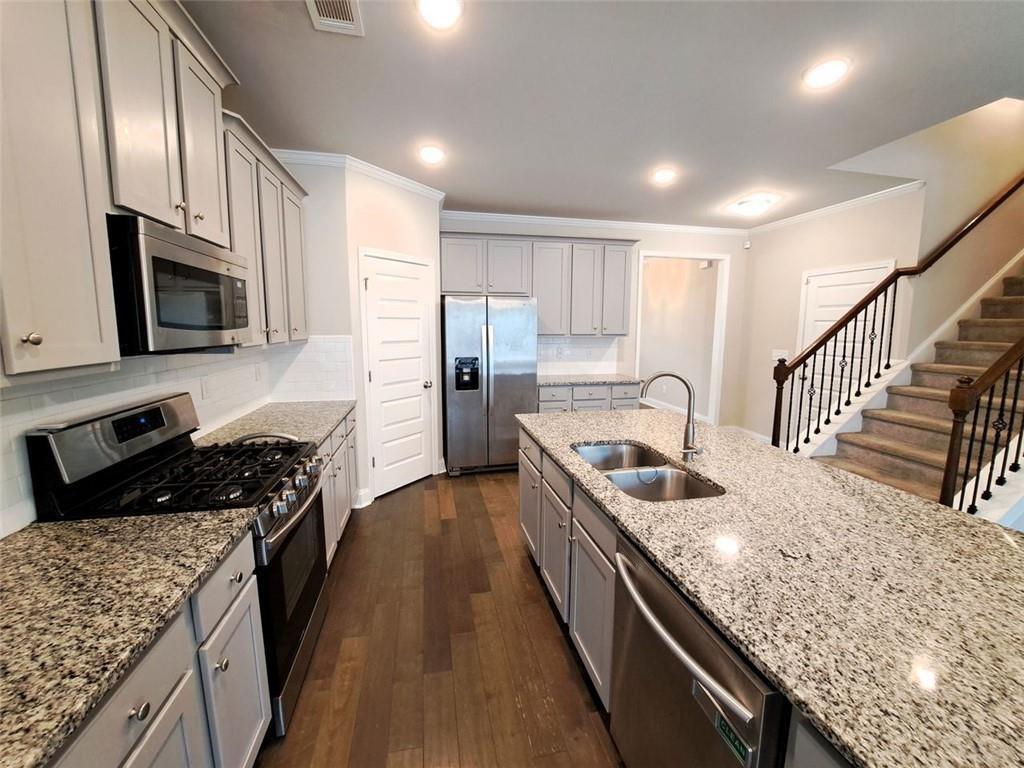512 Hinton Farm Wy. Way Dacula, GA 30019 - Photo 9 of 30 a kitchen with granite countertop a sink a counter top space stainless steel appliances and cabinets