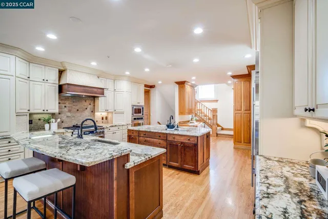 a kitchen with kitchen island granite countertop a sink and a refrigerator