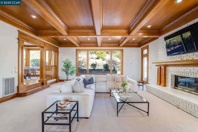 a living room with furniture a fireplace and large windows