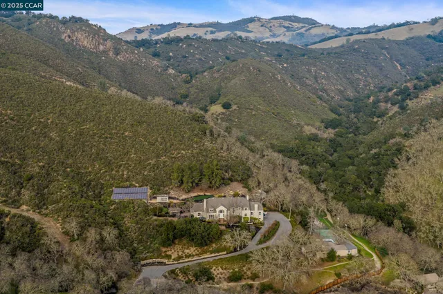 an aerial view of a house with a mountain