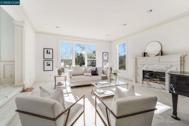 a living room with furniture a fireplace and a large window