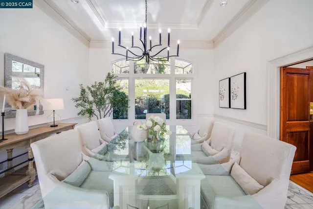 a view of a dining room with furniture a livingroom and chandelier