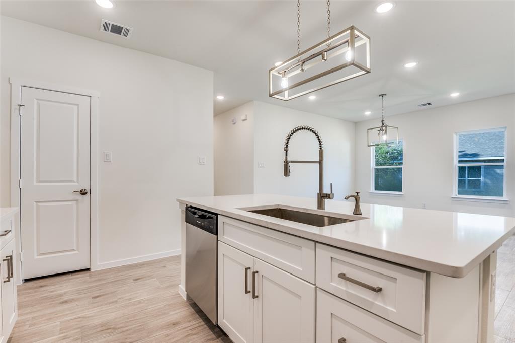 608 Southwest 3rd Street Kerens, TX 75144 - Photo 12 of 25 Kitchen featuring an island with sink, recessed lighting, white cabinetry, light wood-style flooring, and stainless steel dishwasher