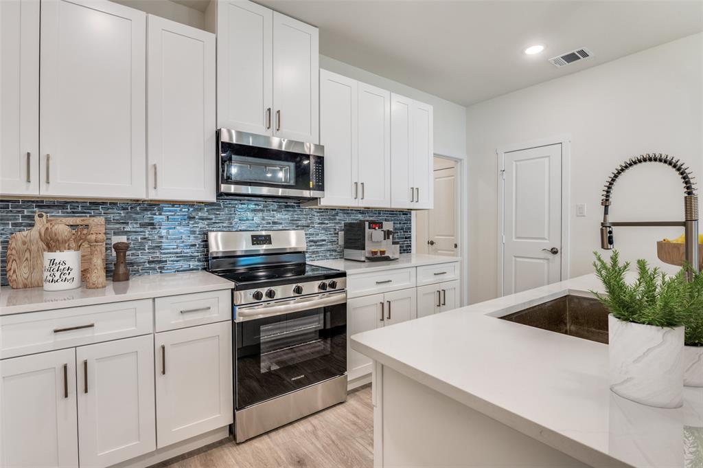 608 Southwest 3rd Street Kerens, TX 75144 - Photo 13 of 25 Kitchen featuring appliances with stainless steel finishes, decorative backsplash, white cabinetry, and recessed lighting