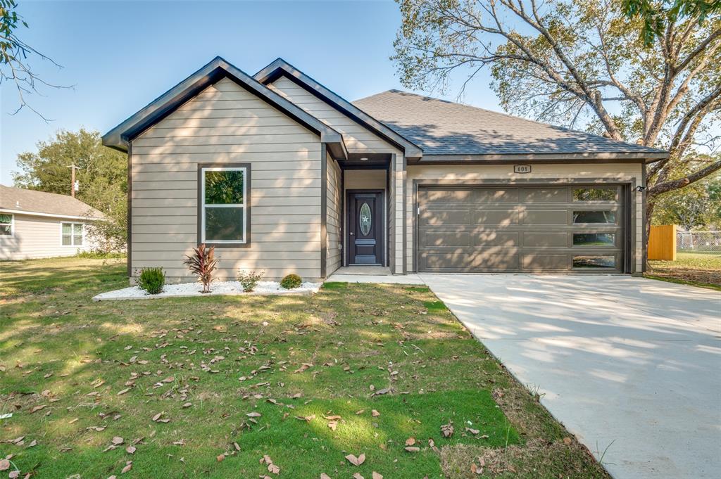 608 Southwest 3rd Street Kerens, TX 75144 - Photo 2 of 25 View of front of property featuring concrete driveway, a front lawn, a garage, and roof with shingles