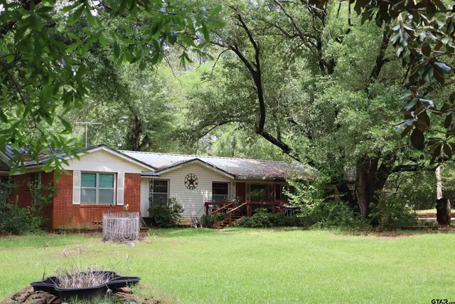 a front view of a house with a garden and yard