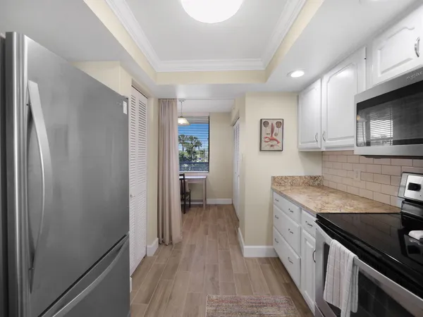 a kitchen with stainless steel appliances granite countertop a refrigerator and a stove top oven