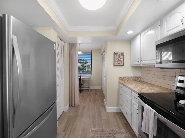 a kitchen with stainless steel appliances granite countertop a refrigerator and a stove top oven