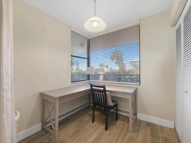 a view of a workspace with furniture and a window