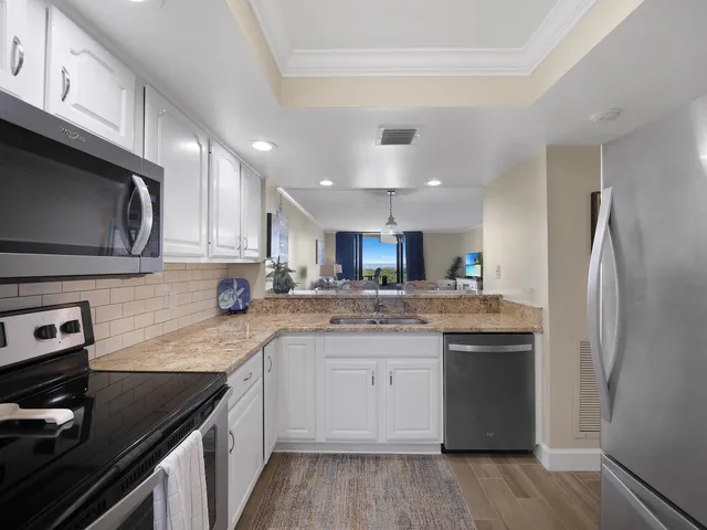 a kitchen with stainless steel appliances granite countertop a sink stove and refrigerator